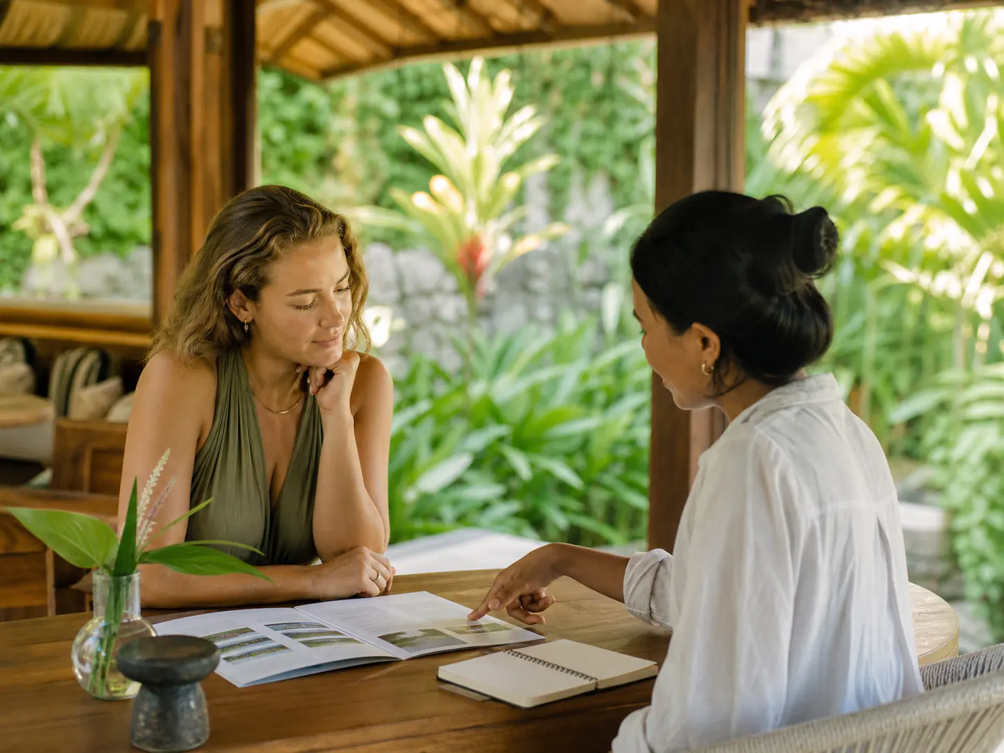 Prospective guest discussing a Bali retreat programme with a retreat coordinator Prospective guest discussing a Bali retreat programme with a retreat coordinator