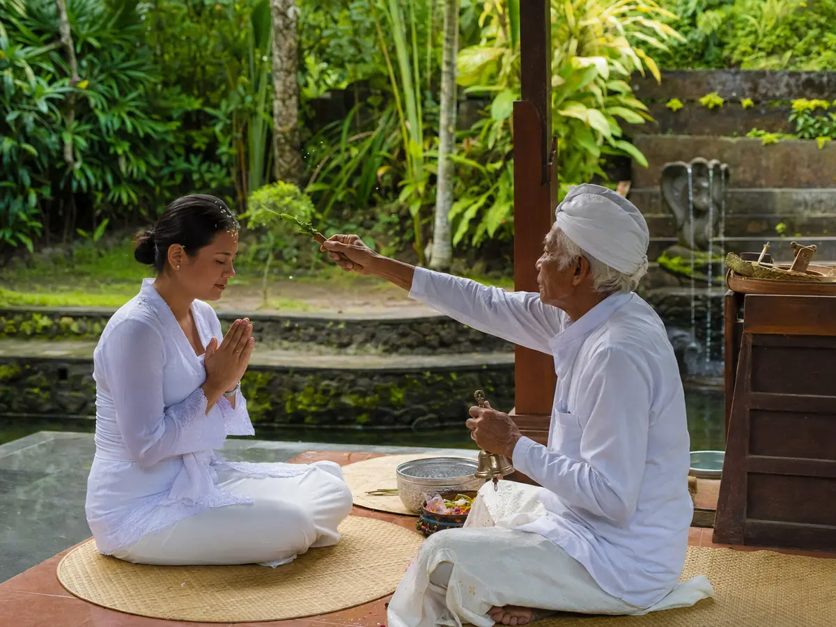 Balinese priest giving a final blessing after a Melukat ceremony in Bali